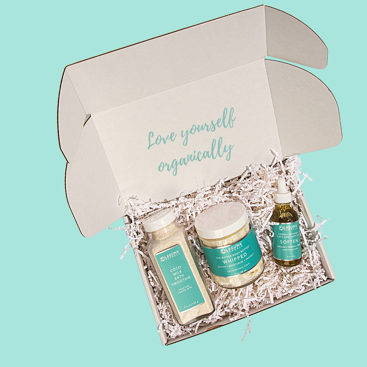 Open gift box with skincare products on a teal background