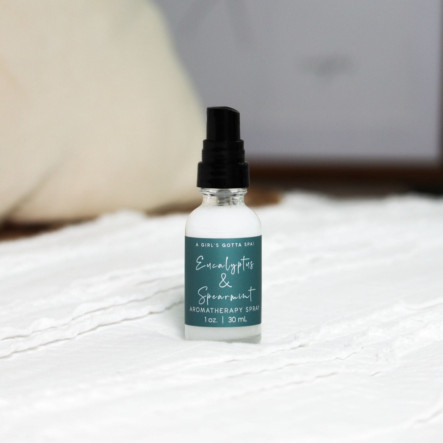 Bottle of Eucalyptus & Spearmint aromatherapy spray on a textured surface with a blurred background