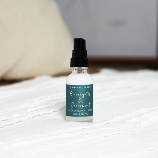 Bottle of Eucalyptus & Spearmint aromatherapy spray on a textured surface with a blurred background